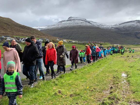a line of people hiking in the faroe islands