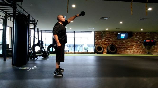 young man lifts weight in gym