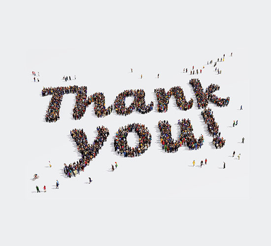 Large group of people seen from above gathered in the shape of words Thank you