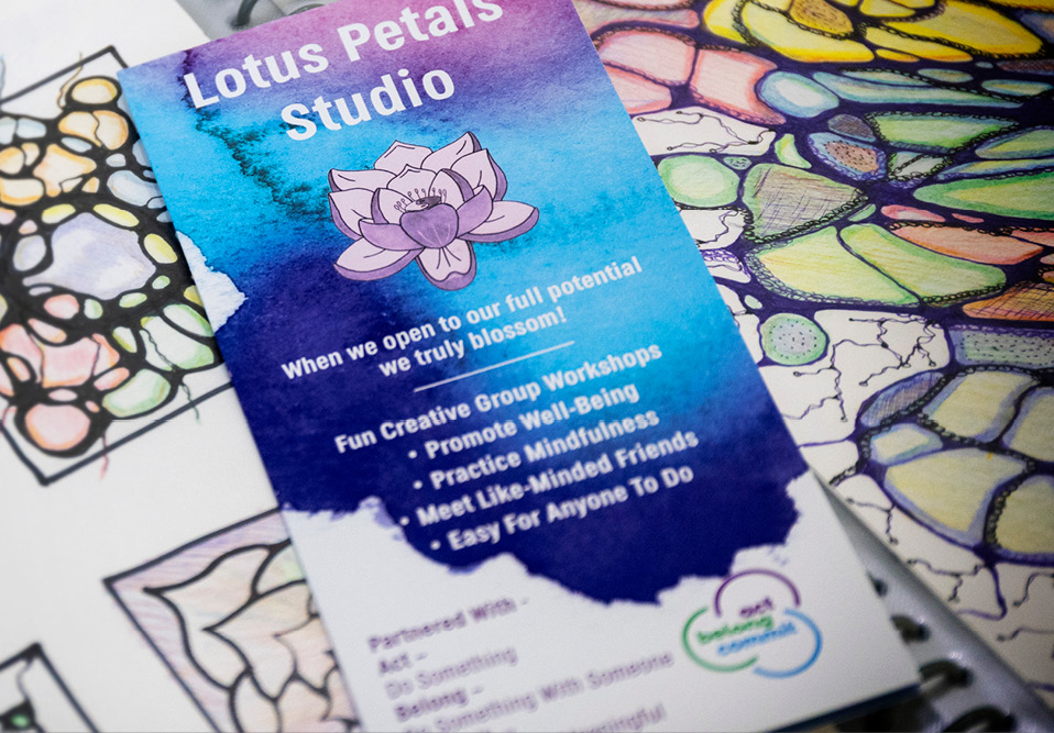 Leaflet sitting on top of colouring pages. Text on leaflet is about Lotus Petals Studio and mental wellbeing.