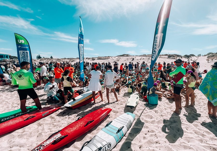 Crowd of people, kayaks and flags at the beach