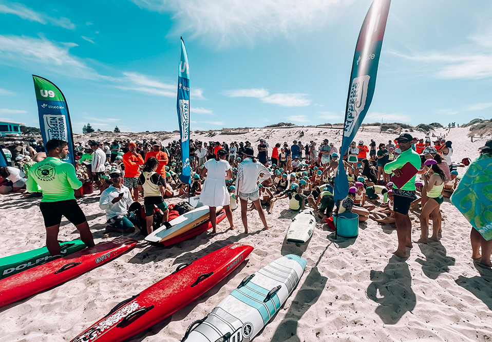 Crowd of people, kayaks and flags at the beach