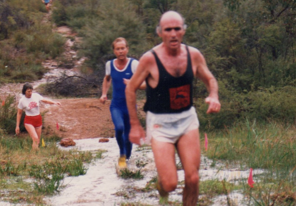 Three people running on a trail.